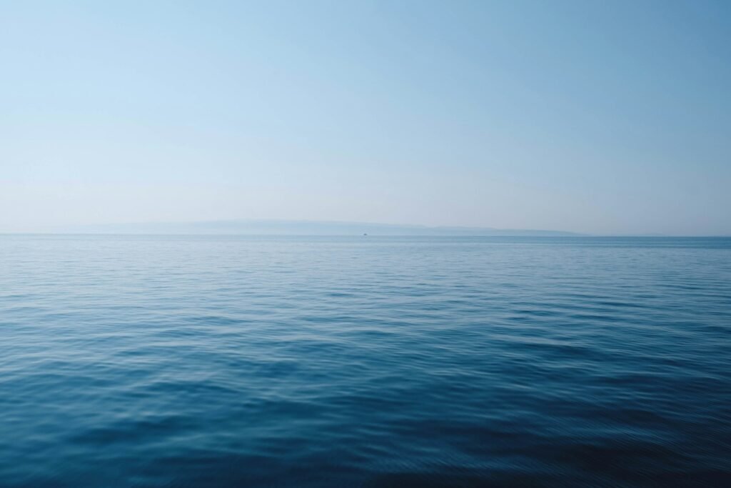 body of water under blue and white sky at daytime